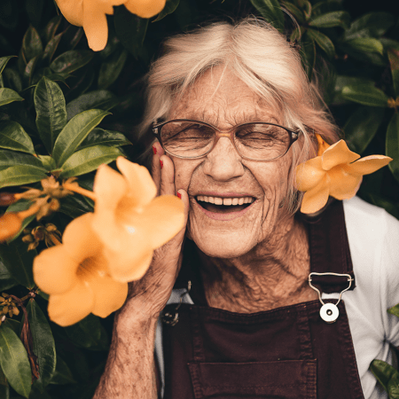 mature woman smiling next to flowers